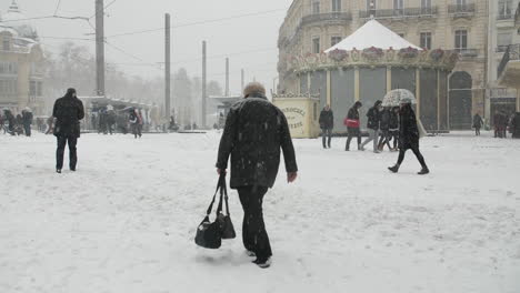 Woman-walking-under-the-snow-in-Montpellier-Comedy-square.-Winter-cold-snowy-day